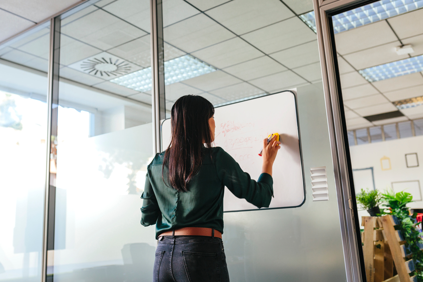 Woman creating customer journey map on a whiteboard